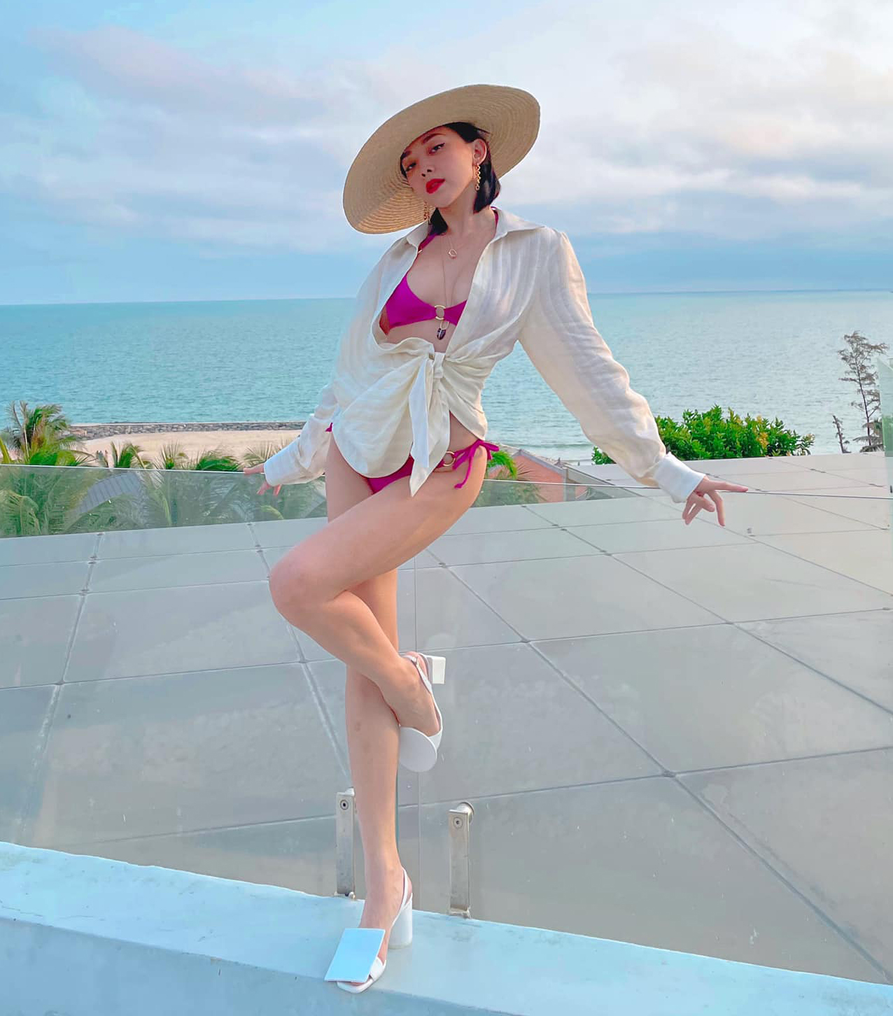 Tóc Tiên đang có chuyến nghỉ dưỡng đầu năm ở biển. Trong khu resort, nữ ca sĩ diện bộ bikini màu hồng tím rất tôn da, kết hợp cùng sơ mi khoác hờ hững phía ngoài và mũ cói theo phong cách cổ điển.